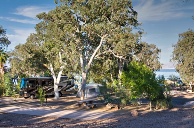 Desert landscape with campsites and two rv's.