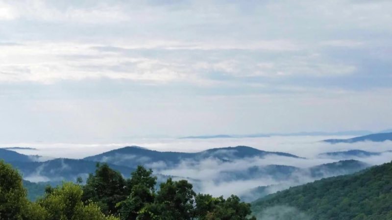 Fog clouds hug the valleys while mountain tops rise above the sea of white