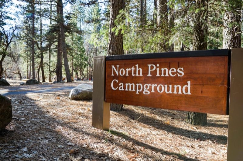 A wood sign at the entrance of a campground reads, North Pines Campground.